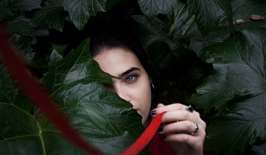 Голубоглазая девушка в больших зеленых листьях