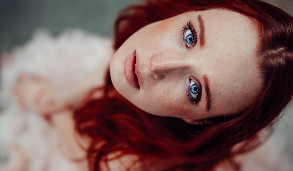 Голубоглазая рыжеволосая девушка с веснушками на лице