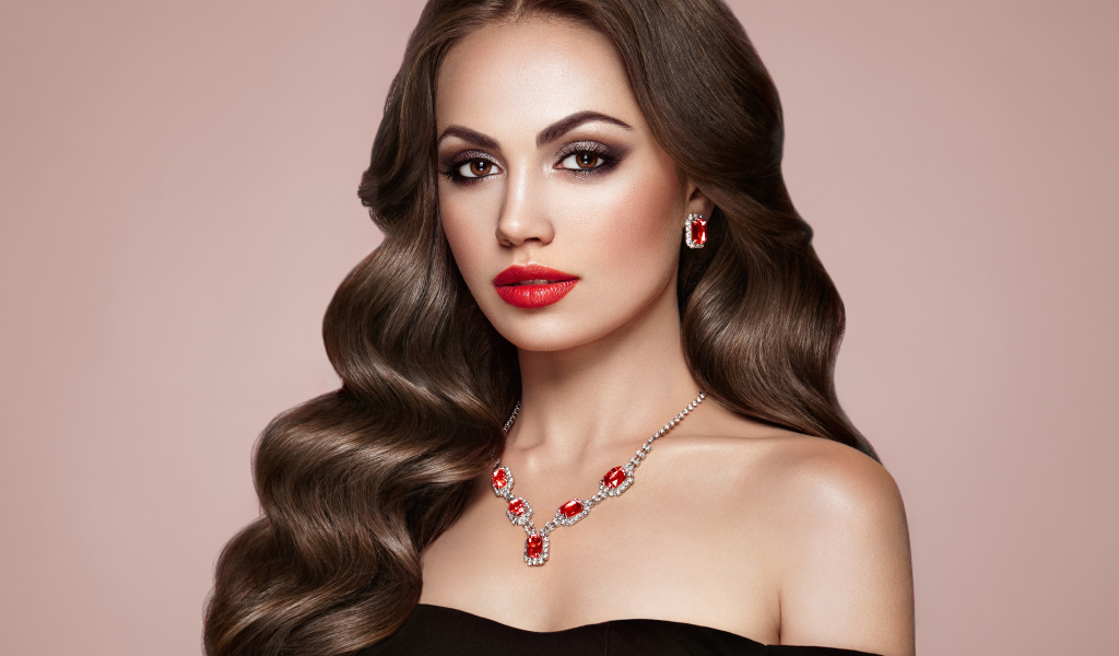 Яркая красивая девушка с украшениями на розовом фоне