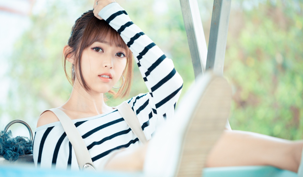 Кареглазая девушка азиатка в полосатом свитере