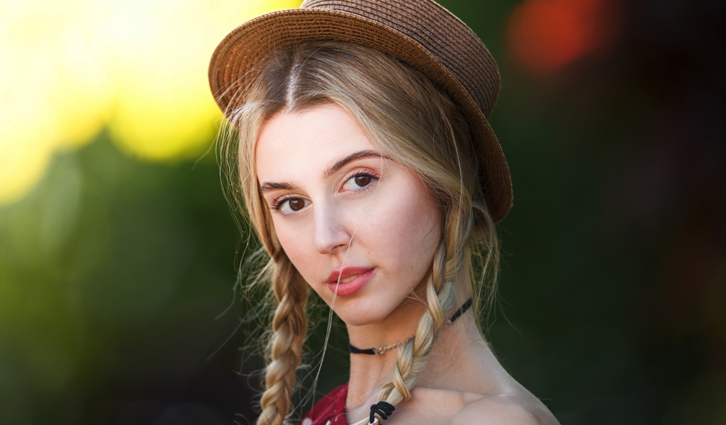 Кареглазая девушка с косами на голове в шляпе