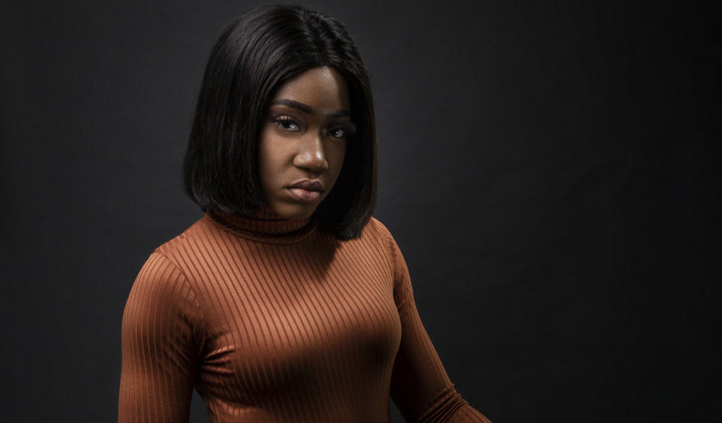 Темнокожая девушка с короткой стрижкой на сером фоне