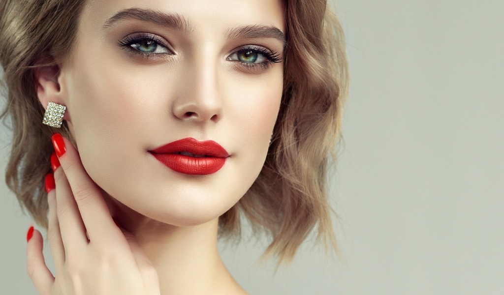 Лицо девушка с красивым макияжем на сером фоне