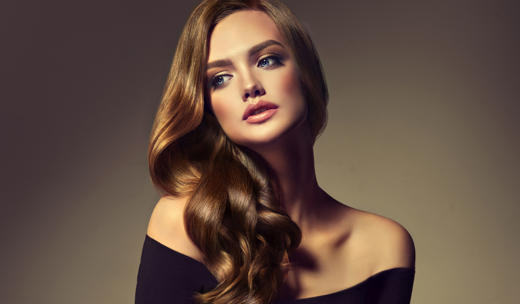Нежная голубоглазая модель с длинными волосами на сером фоне