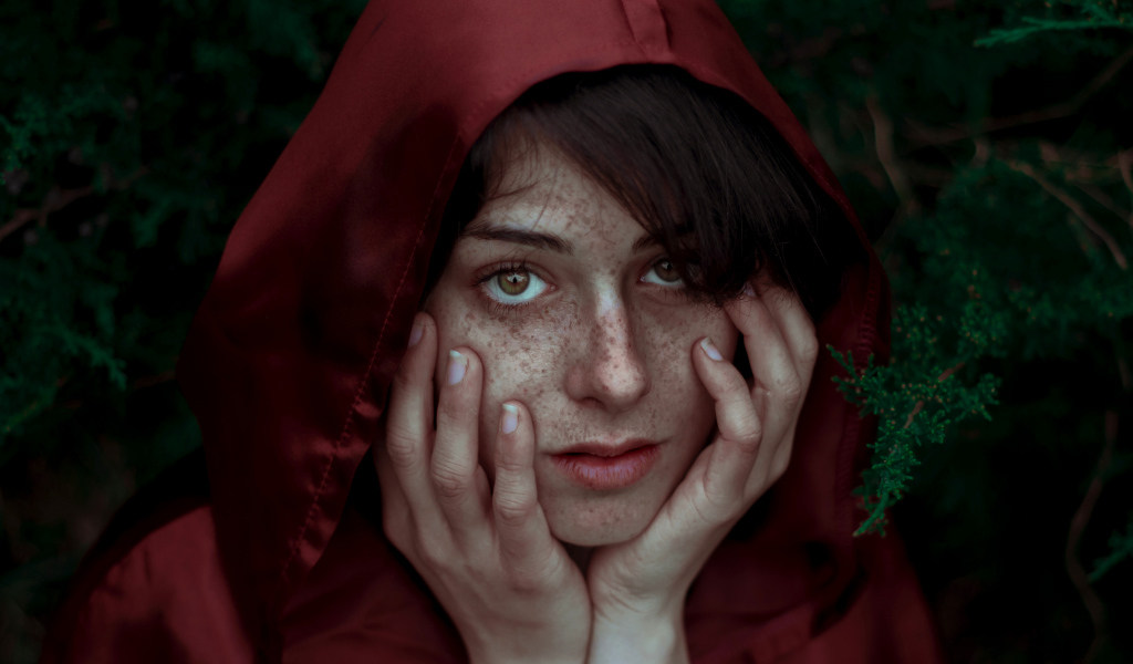 Девушка в красном плаще с веснушками на лице