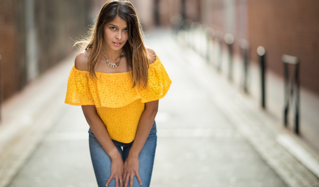 Девушка в джинсах стоит на улице 