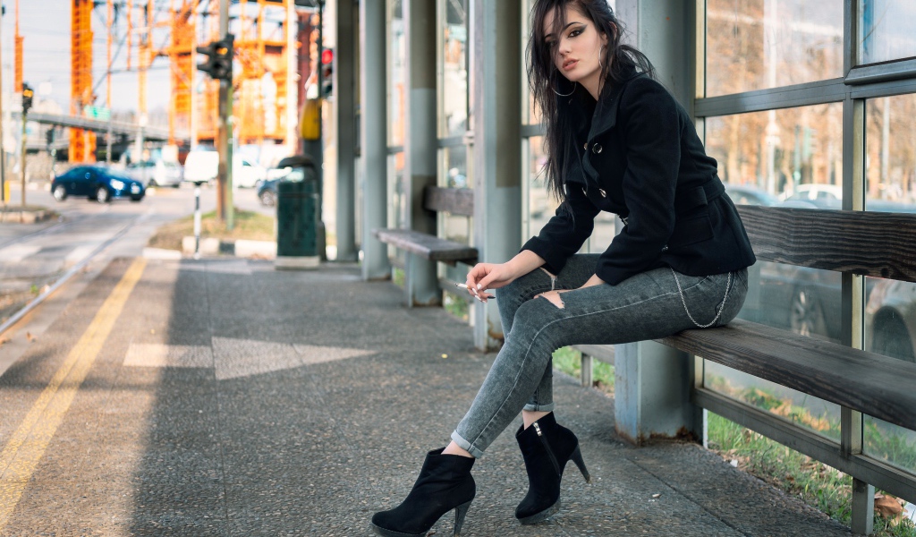 Девушка неформалка сидит на автобусной остановке