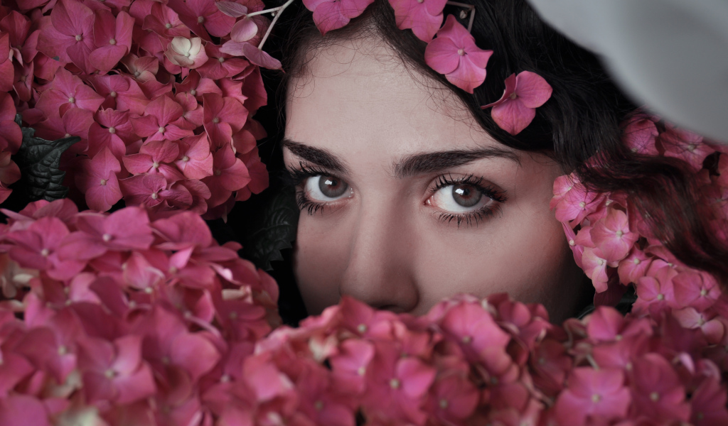 Лицо девушки в розовых цветах гортензии