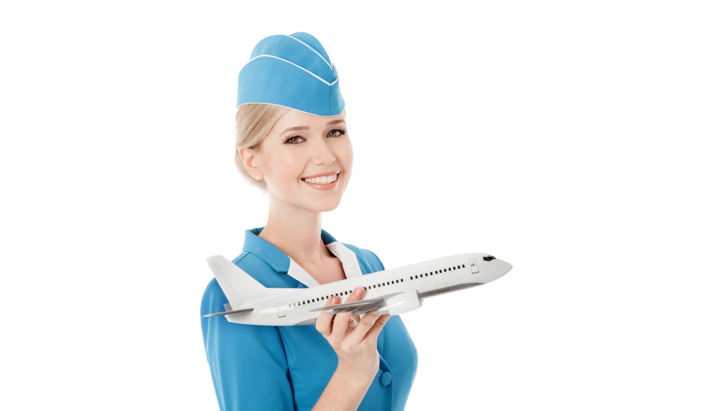 Девушка стюардесса с самолетом в руке на белом фоне