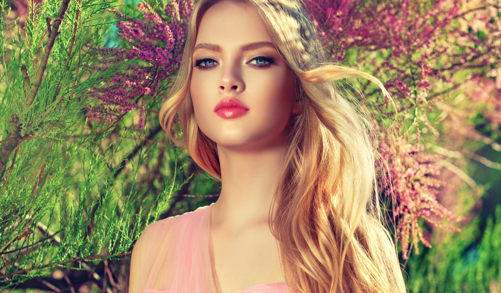 Девушка с красивыми голубыми глазами у цветущего дерева