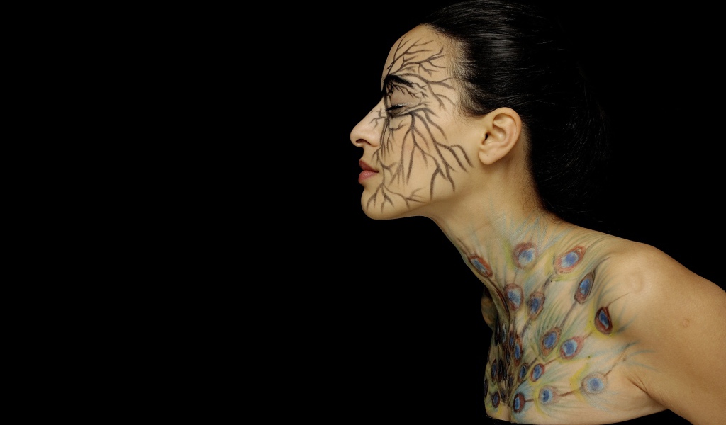 Девушка с рисунками на теле на черном фоне