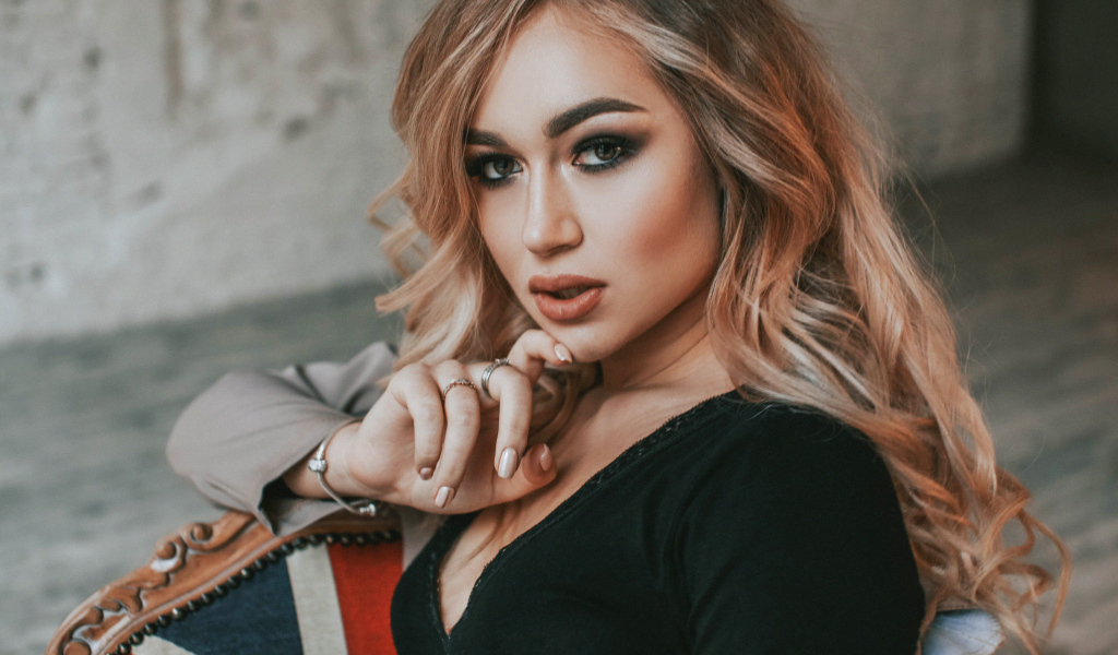 Горячая девушка с макияжем сидит на стуле