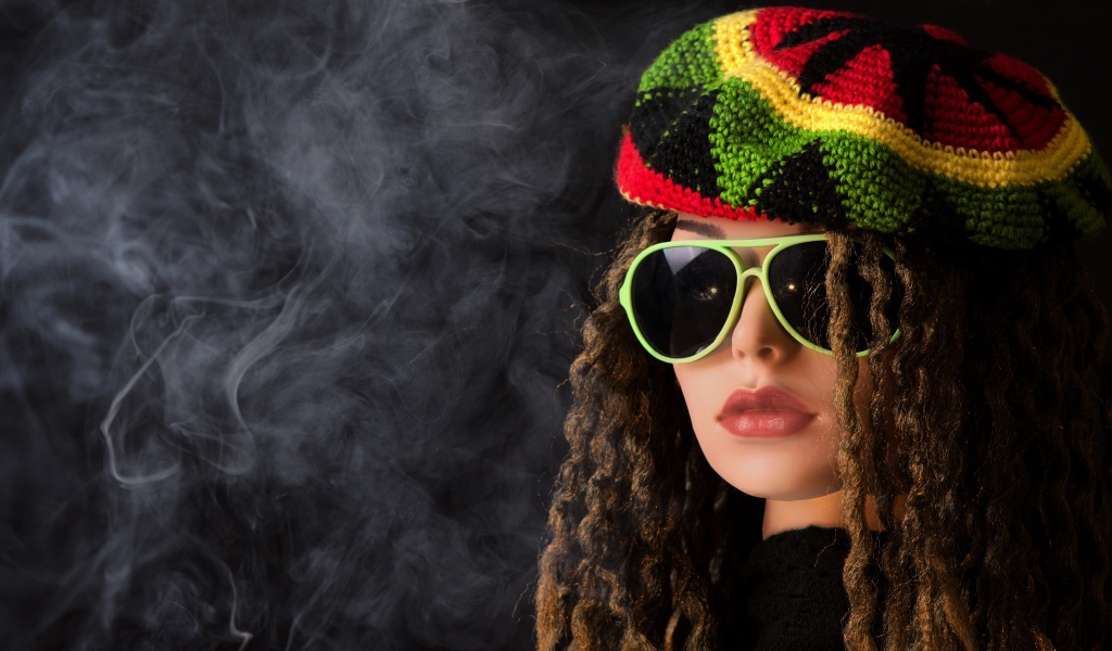 Девушка растаманка в черных очках в дыму