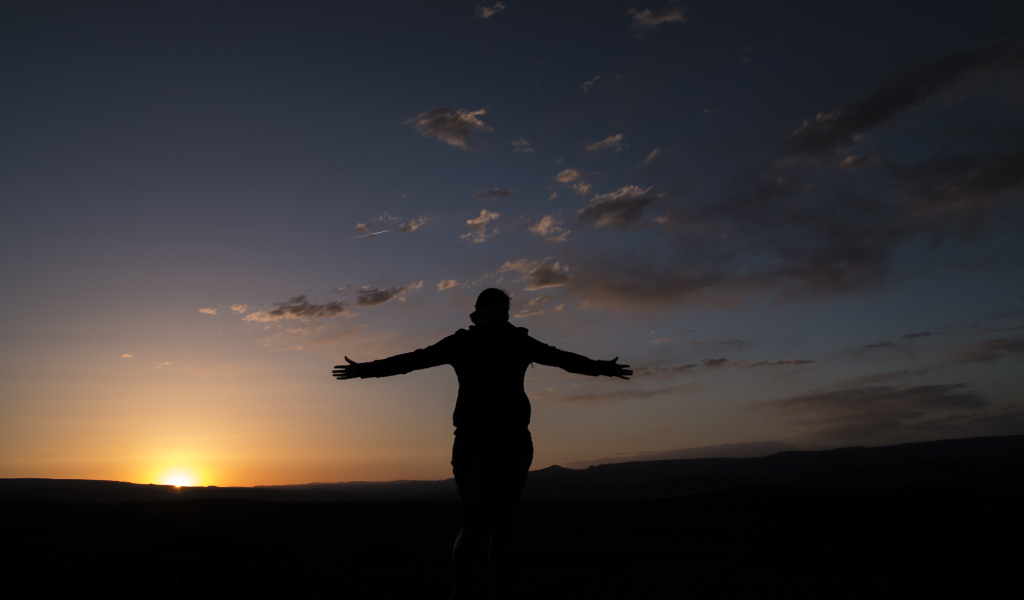 Силуэт девушки на фоне неба на закате