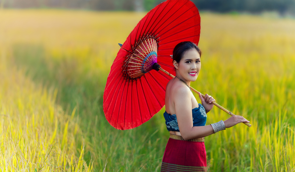 Улыбающаяся девушка азиатка с красным зонтом