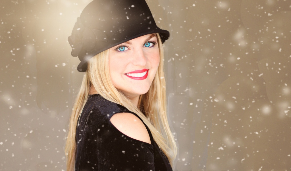 Улыбающаяся голубоглазая девушка в черной шляпе