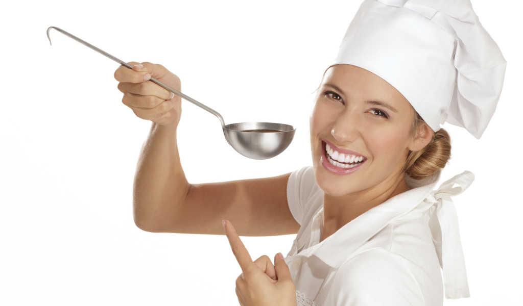 Улыбающаяся девушка в костюме повара с половником