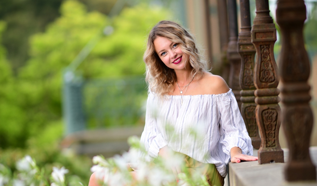 Улыбающаяся девушка сидит на ступенях