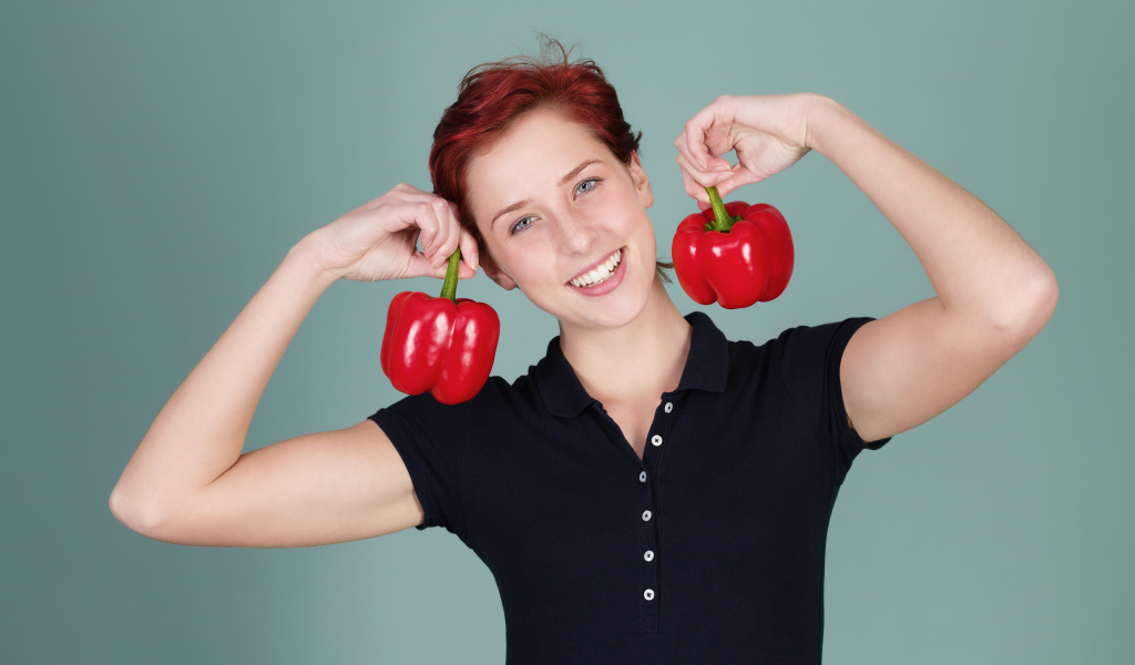 Улыбающаяся девушка с болгарским перцем в руках