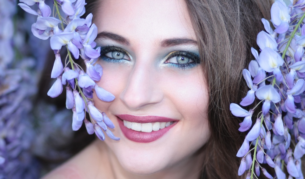 Улыбающаяся девушка с цветами глицинии