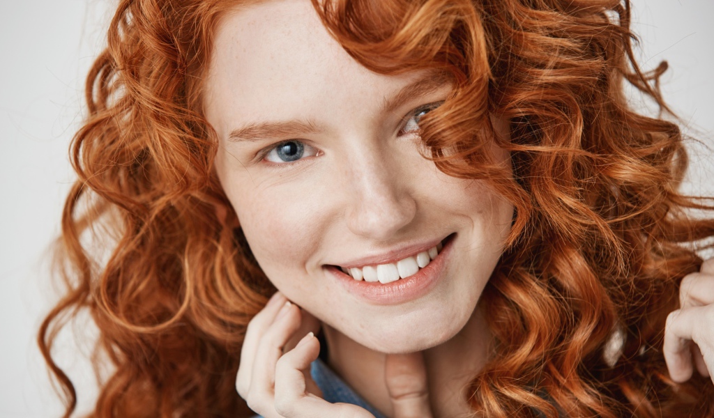 Улыбающаяся рыжеволосая девушка лицо крупным планом