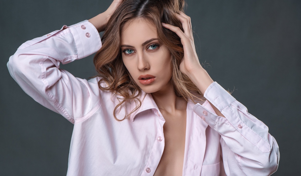 Стильная девушка в розовой рубашке на сером фоне