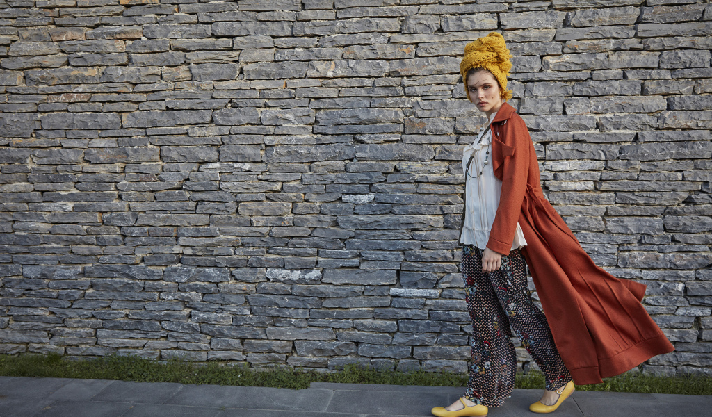 Стильная девушка на фоне стены 