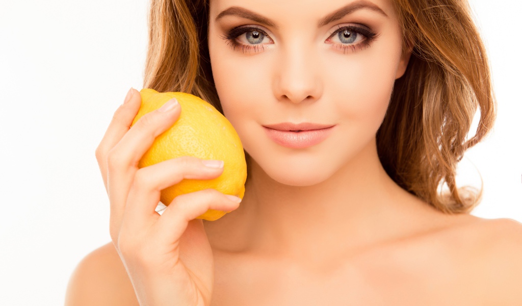 Нежная голубоглазая девушка с лимоном в руке