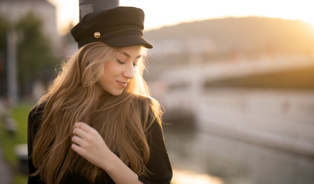 Нежная девушка в черной кепке в лучах солнца