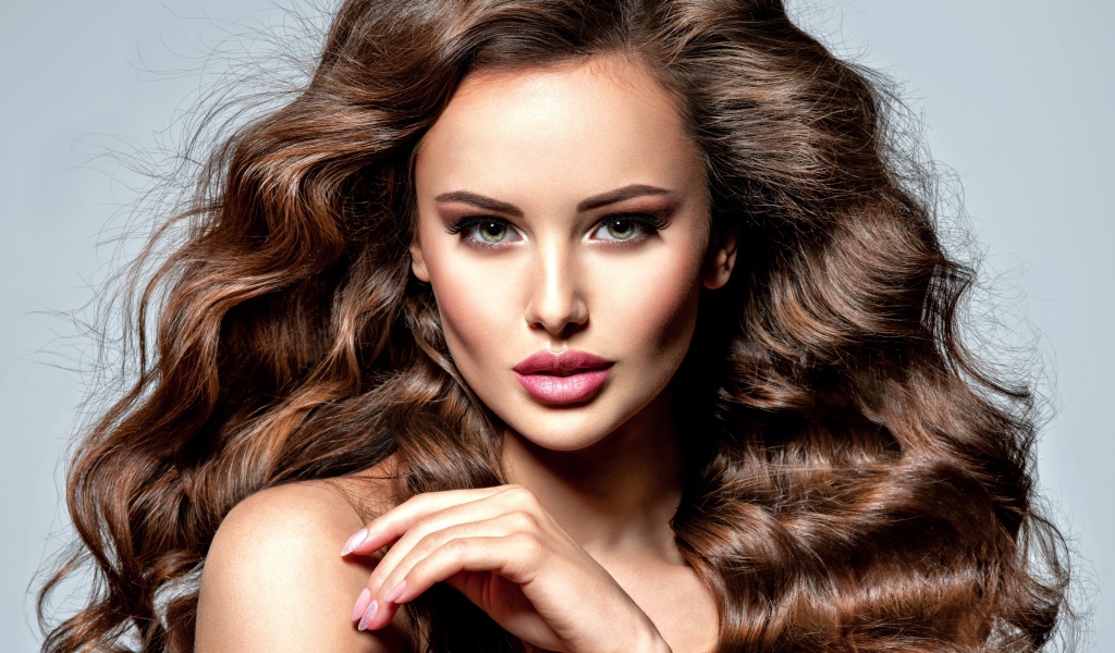 Девушка с красивыми длинными волосами на сером фоне