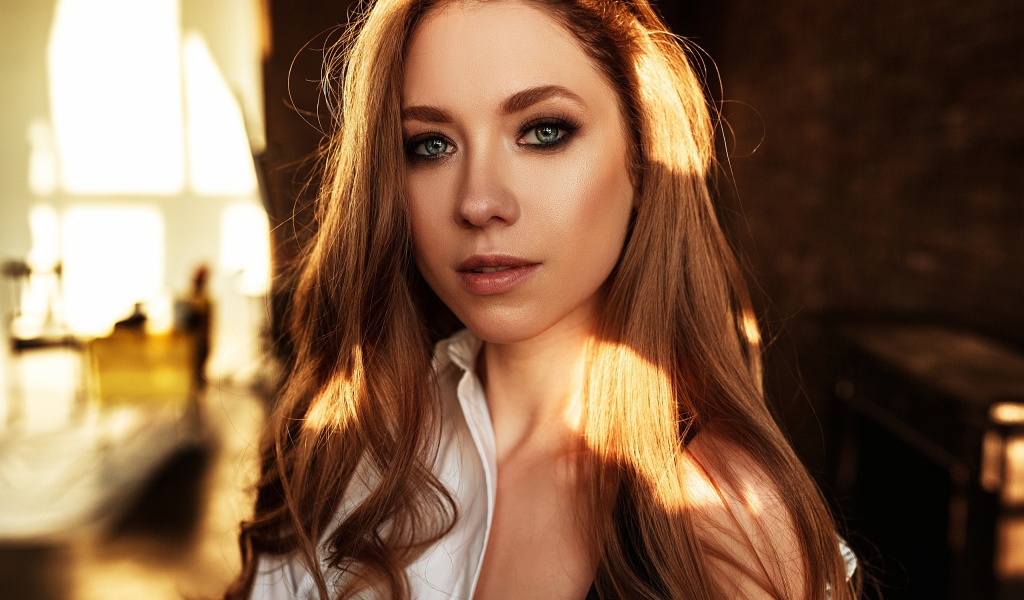 Лучи солнца нападают на волосы голубоглазой шатенки 