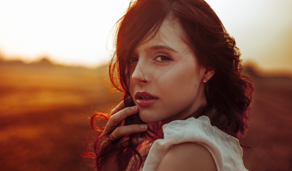 Ветер развивает волосы молодой девушки 