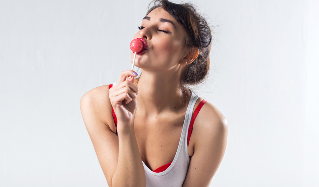 Молодая девушка с конфетой на палочке