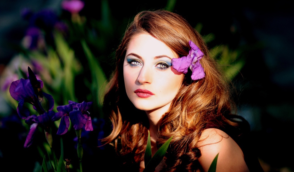 Молодая девушка с фиолетовым цветком ириса в волосах