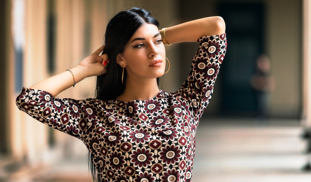 Молодая длинноволосая шатенка с руками в волосах