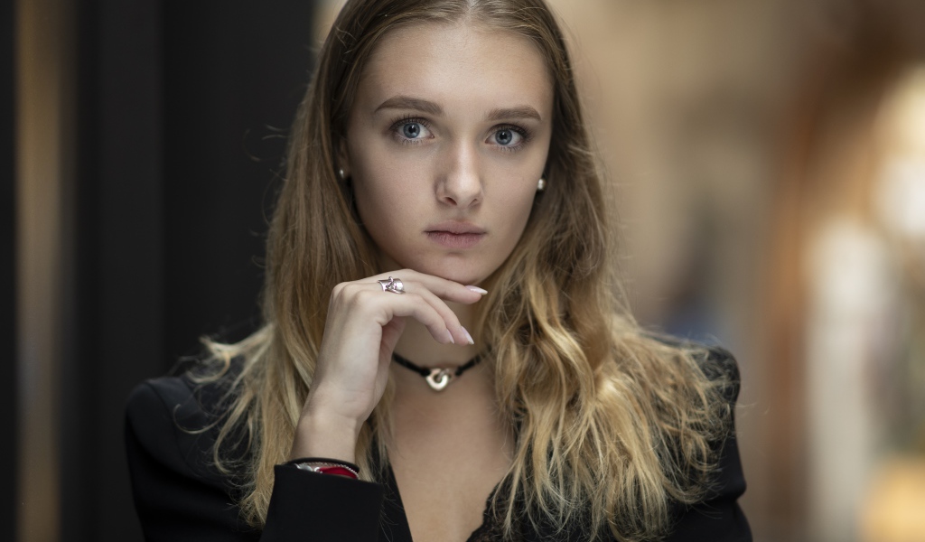 Молодая нежная голубоглазая девушка с рукой у лица