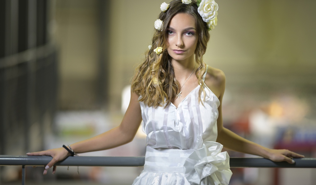 Красивая девушка в белом платье с цветами в волосах 