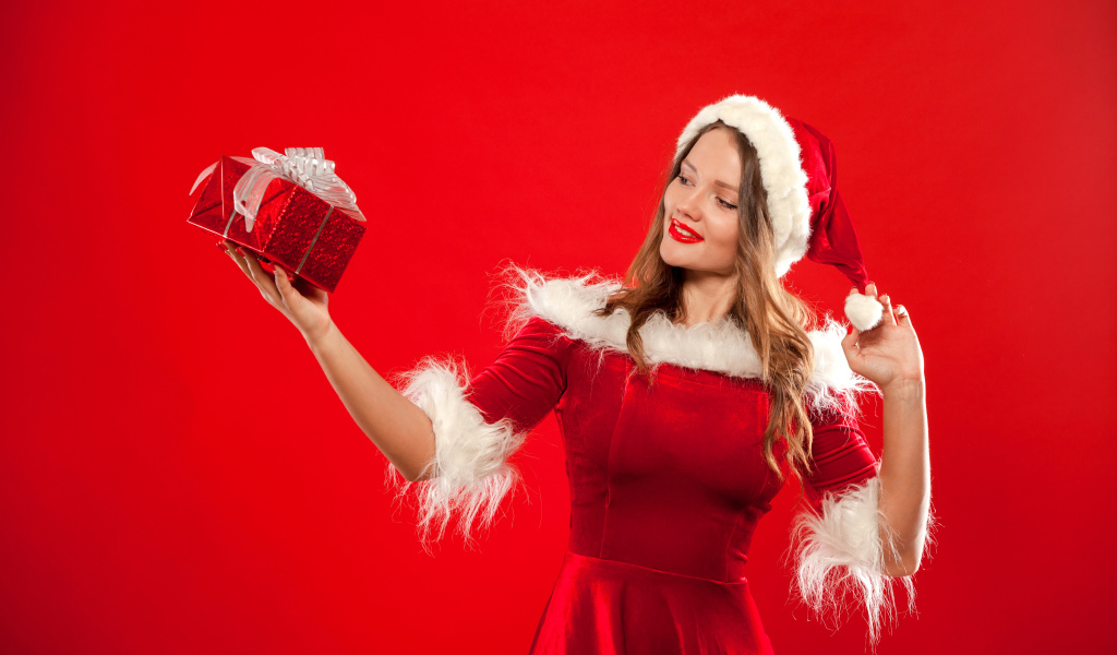 Красивая Снегурочка с подарком в руке на красном фоне