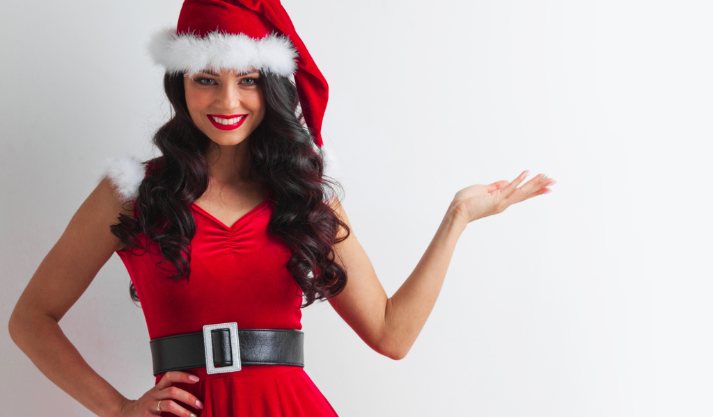 Улыбающаяся девушка в новогоднем костюме на сером фоне