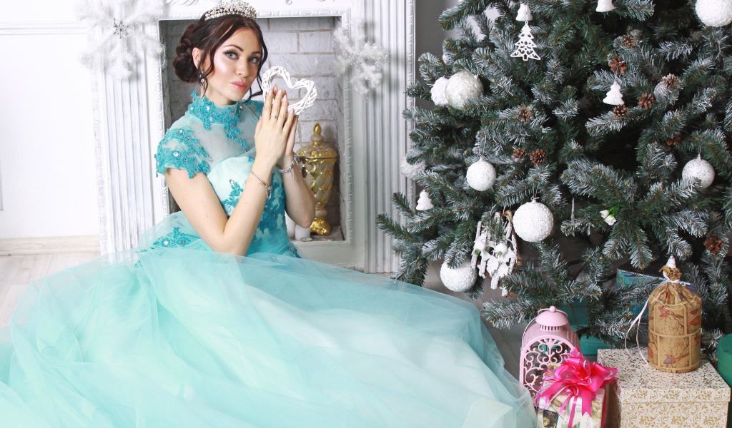 Молодая девушка в красивом голубом платье у новогодней елки