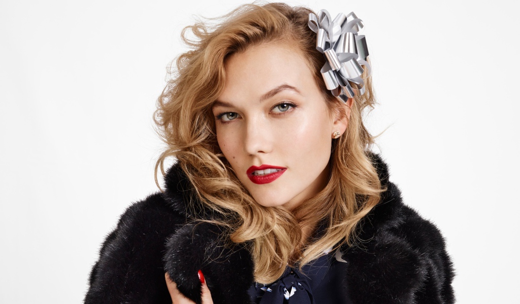Модель Карли Клосс в черной шубе на белом фоне