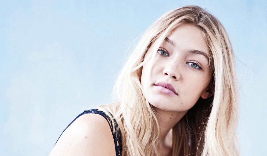 Молодая блондинка, модель Джиджи Хадид на сером фоне