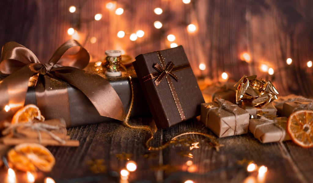 Много подарков на деревянном фоне с гирляндой
