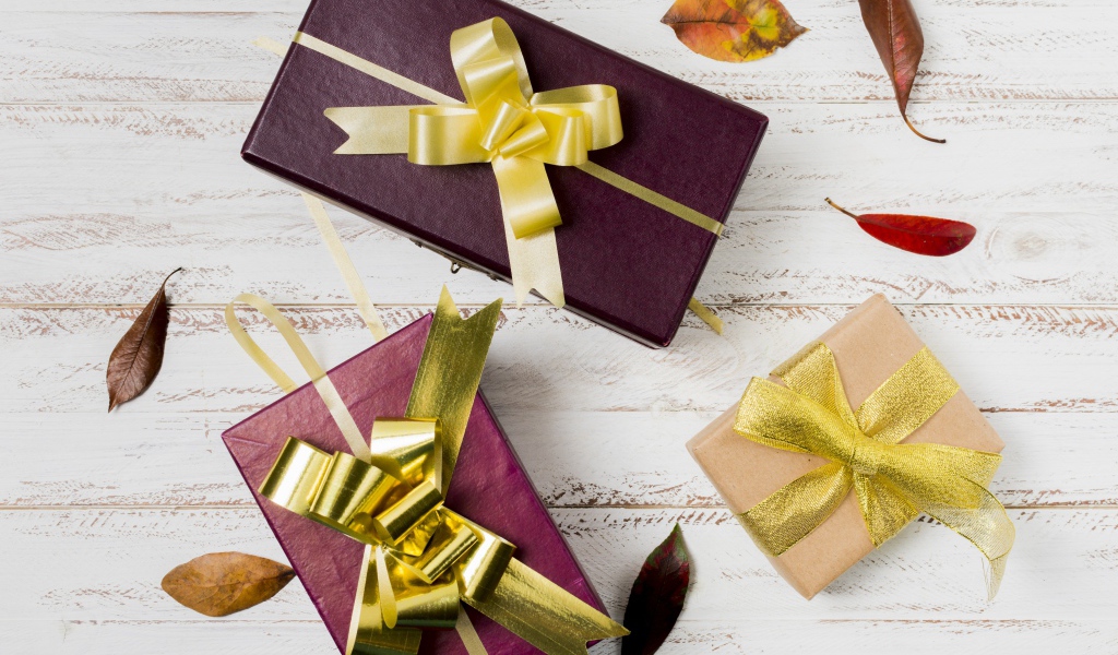 Три подарочные коробки с бантами на столе