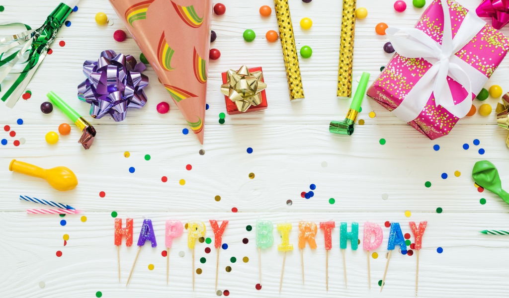 Надпись с Днем рождения на столе с подарками и украшениями