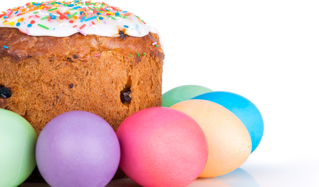 Пасхальный кулич с изюмом на белом фоне с крашеными яйцами 