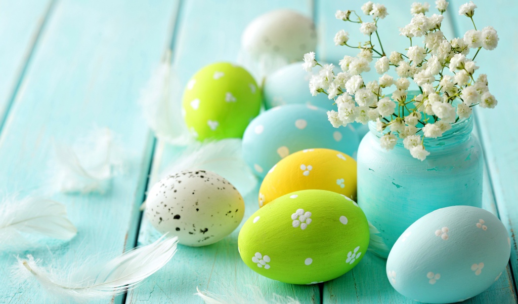 Крашеные яйца с цветами на голубом столе 
