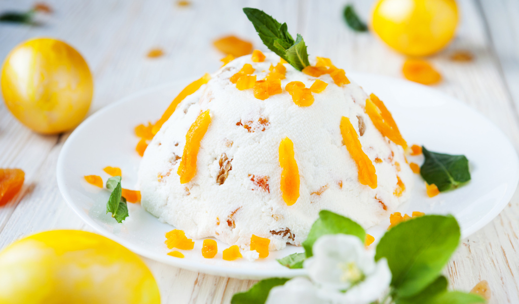 Сладкая творожная пасха с курагой на столе с крашеными яйцами