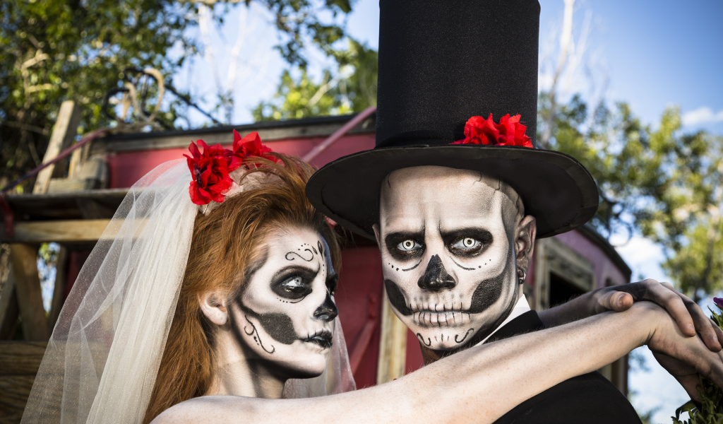 Пара жених и невеста с масками с грима на лице на Хэллоуин 