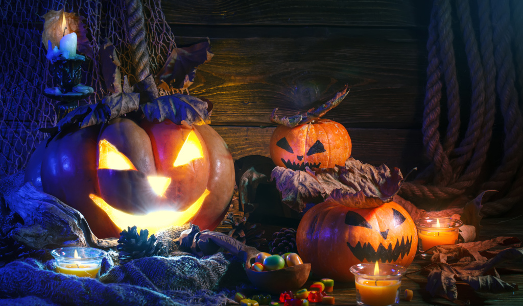 Зловещие тыквы на столе со сладостями на праздник Хэллоуин 